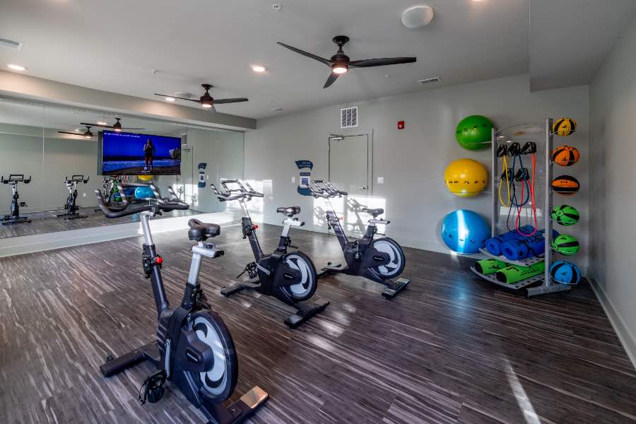 You should always know your roommates' schedules. They might enjoy getting up early to use a fitness center like this one at Verge Luxury Flats. Apartment fitness center with a mirrored wall, exercise bikes, and stability balls.