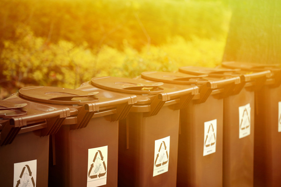 Take advantage of recycling bins and incorporate reusable items into your daily life. Row of recycling containers for tenants