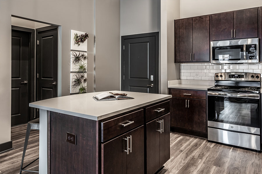 Spacious apartments like this one at Spark Apartments in Fishers will give your pet room to roam. Upscale apartment kitchen with island and dark wood cabinetry