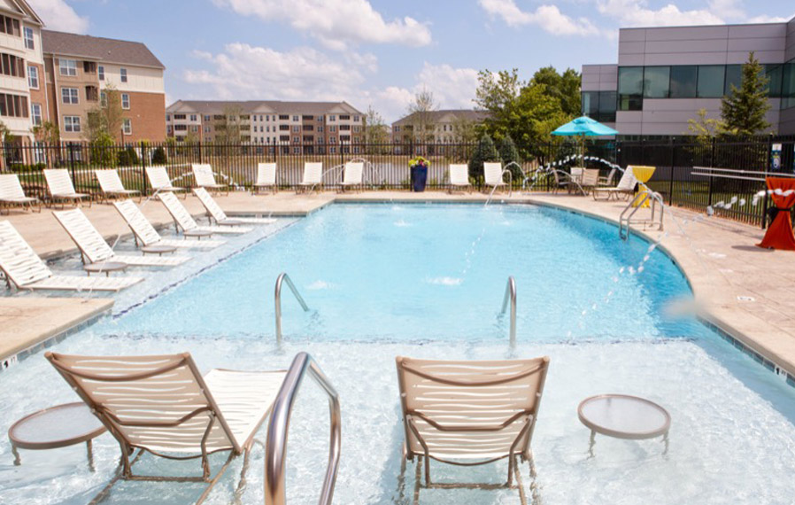 A beautiful blue pool enhances your apartment experience in Plainfield. Lake side pool on a sunny day.