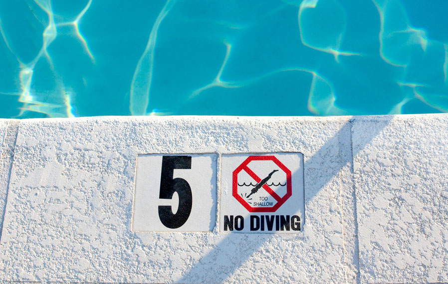 Be responsible, safe and have fun at the pool. Up close shot of the pool's no diving sign.