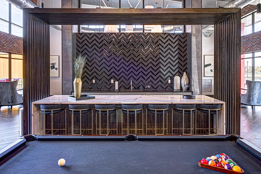 The State at Fishers apartments offers an incredible clubhouse, including this pool table and bar seating. Pool table and bar seating inside the clubhouse of The State at Fishers apartments